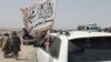 PAKISTAN - People wave a Taliban flag as they drive through the Pakistani border town of Chaman on July 14, 2021, after the Taliban claimed they had captured the Afghan side of the border crossing of Spin Boldak along the frontier with Pakistan